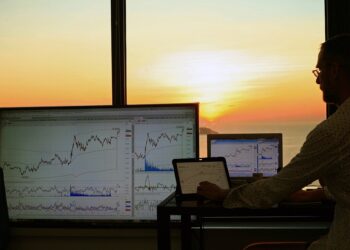 Person trading with 3 personal computers