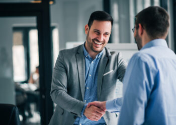 Portrait of cheerful young manager handshake to approve his credit
