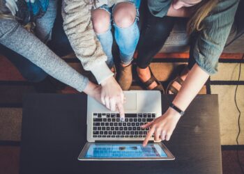 Three person watching laptop screen