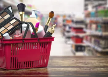 Cosmetics in shopping basket on shelf in shop. Beauty and make u