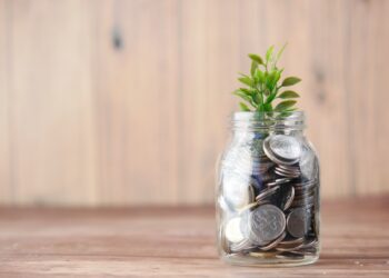 Clear glass vase with coins