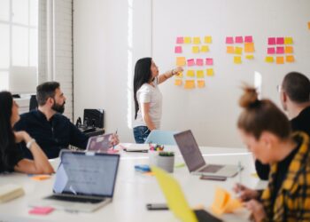 Woman placing sticky notes in wall paper during a meet