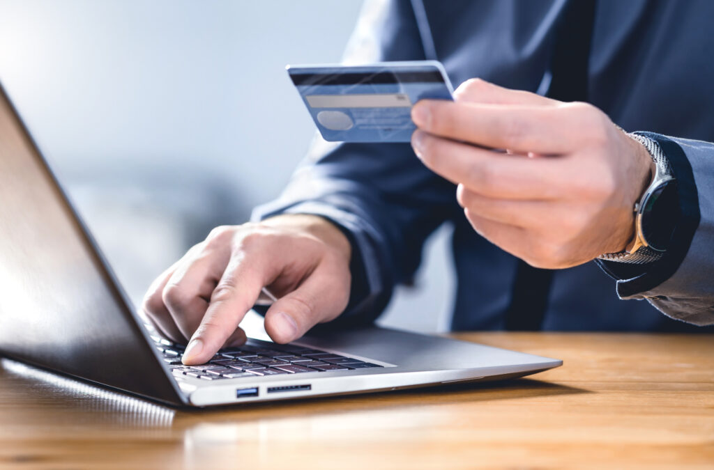 Man using credit card and laptop to login to internet bank.