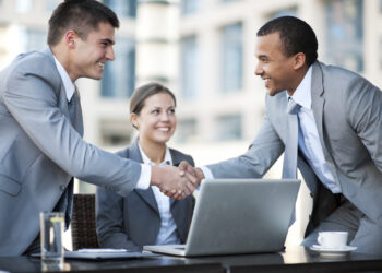 Two businessmen are shaking hands at the meeting | FintechZoom