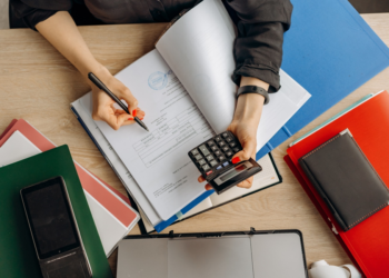 A Person Examining Documents | FintechZoom