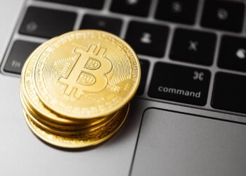Golden bitcoins over silver laptop
