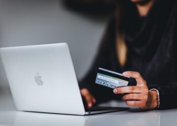 Person using credit card in Laptop | FintechZoom