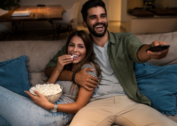 Couple watching TV with popcorns | FintechZoom