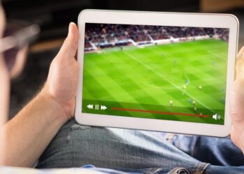 Person using tablet to watch sports streaming | FintechZoom
