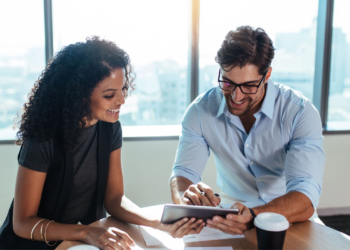 Man and Woman looking to a tablet | FintechZoom