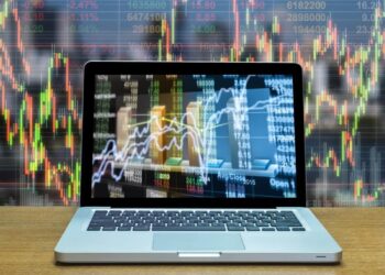 Laptop on table with several charts | FintechZoom