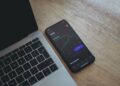 Mobile with Tesla Stock Chart near Laptop | FintechZoom
