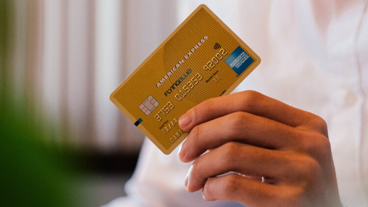 Person holding credit card | FintechZoom