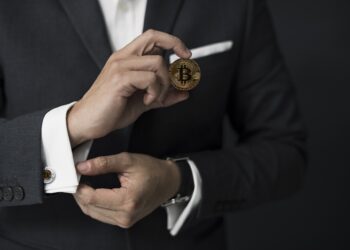 Business Man with suit and holding a bitcoin | FintechZoom