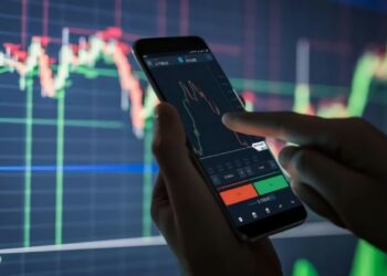 Person using mobile to buy stocks and stock chart at background | FintechZoom