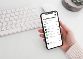 Person with mobile using APP for Scheduled payments | FintechZoom