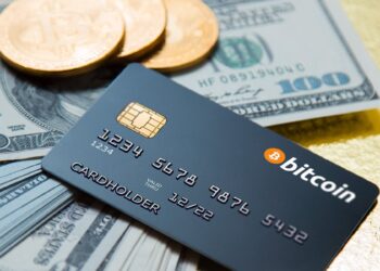 3 Bitcoins, credit Card and dollars on table | FintechZoom