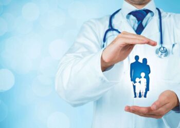 Doctor protecting with his hands a family model | FintechZoom