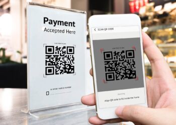 Person using Mobile phone to pay by scanning QR Code | FintechZoom