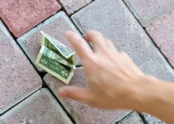 Person pick money from the ground | FintechZoom