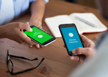 Two-People-Holding-Their-Phones-While-Someone-Sends-Money | FintechZoom