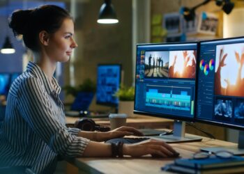 Woman on computer composing Videos | FintechZoom