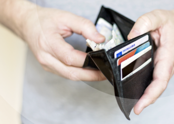 Man looking for money on his wallet | FintechZoom