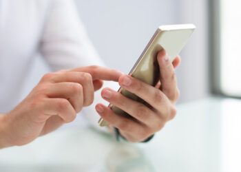 photo close-up of male hands using smartphone | FintechZoom