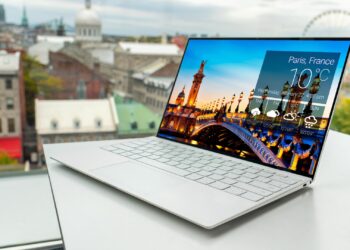 Laptop on Table with Paris City on Background | FintechZoom