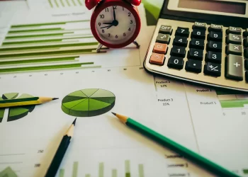Budget Plan on desk with calculator and pencil | FintechZoom