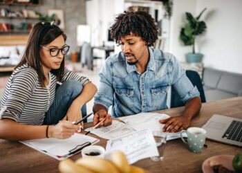 Multi ethnic couple planning their home budget | FintechZoom