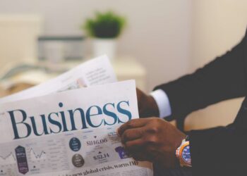 Business man reading Business Newspaper | FintechZoom