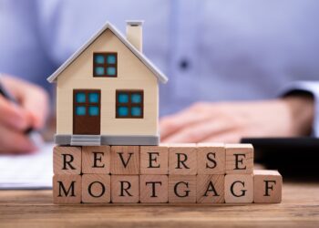 Reverse Mortgage writing in wood cubes with home model over | FintechZoom