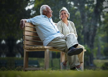 2 old persons sitting on a Garden chair | FintechZoom
