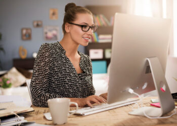 Young woman in front of her computer | FintechZoom