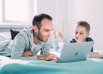 Kid on laptop with father | FintechZoom