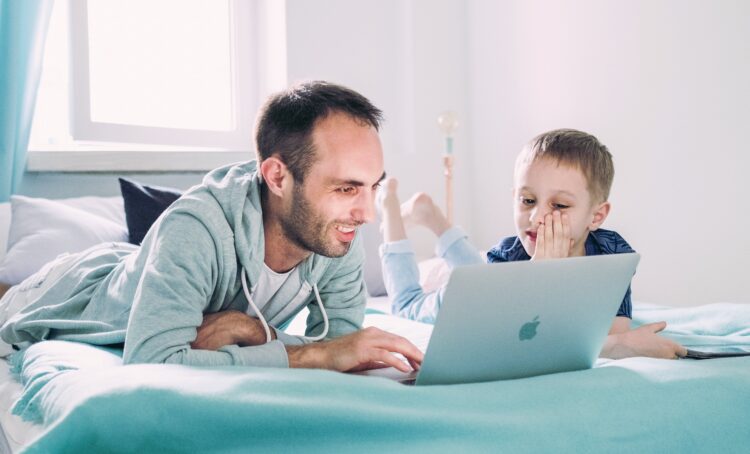Kid on laptop with father | FintechZoom