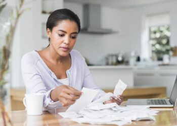 Woman checking her bills | FintechZoom