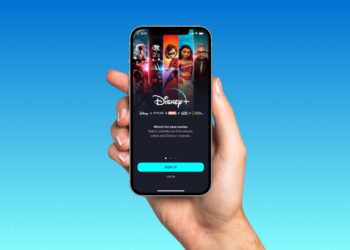 Person holding smartphone with Disneyplus app | FintechZoom