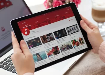 Person watching Youtube in Tablet - व y2mate| FintechZoom