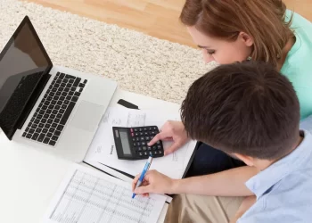 Couple on laptop paying bills | FintechZoom