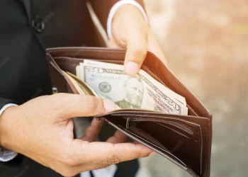 Business person holding an wallet in the hands of an man no money have a little money | FintechZoom