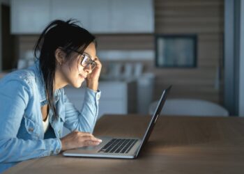 Woman using laptop | FintechZoom