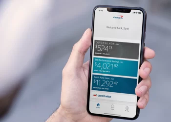 Person holding smartphone with Capital One App | FintechZoom