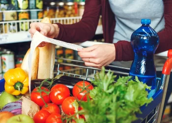 woman looking at grocery receipt | FintechZoom