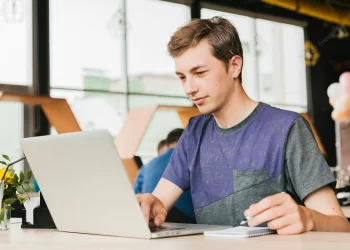 Young man cafe working laptop | FintechZoom