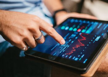 Person looking for a chart in tablet | FintechZoom