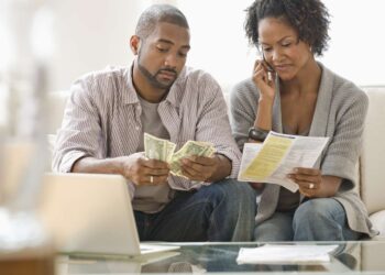 Couple paying bills | FintechZoom