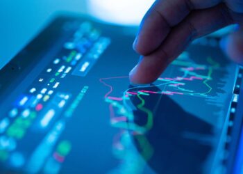 Person with finger over stock chart | FintechZoom