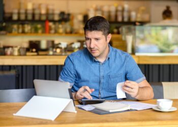 Owner looking to bills in his small business | FintechZoom